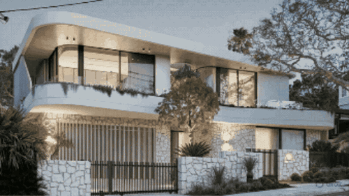 Contemporary harbourside house with a curved white facade at dusk