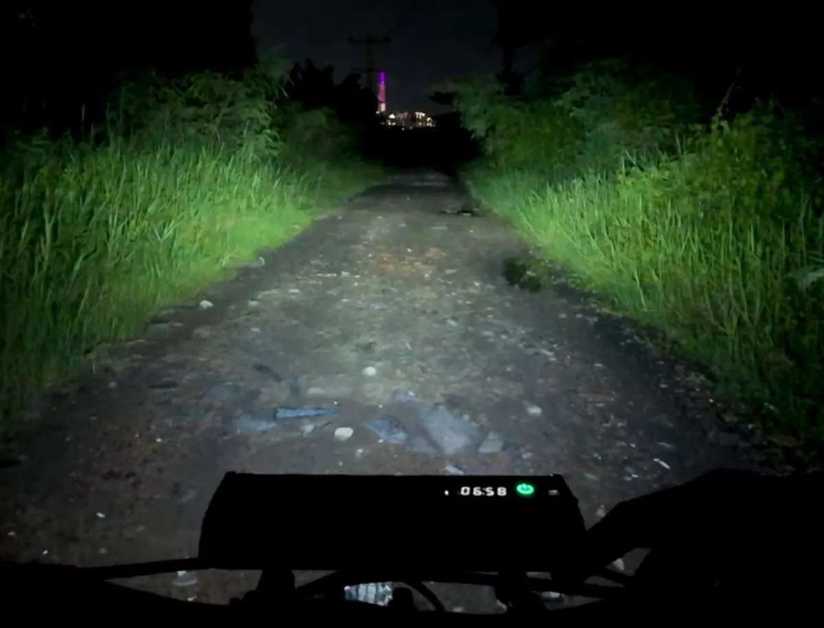 Newboler bike light beam illuminating a dark gravel trail at night, showing wide throw and visibility range during real ride test