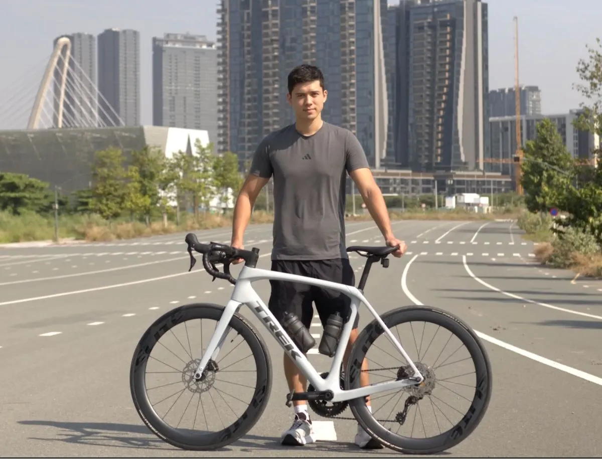 Mike Dee of BikeLabHQ standing with his Trek Domane SL5 fitted with Elitewheels ENT 2.0 carbon wheels on an open city road