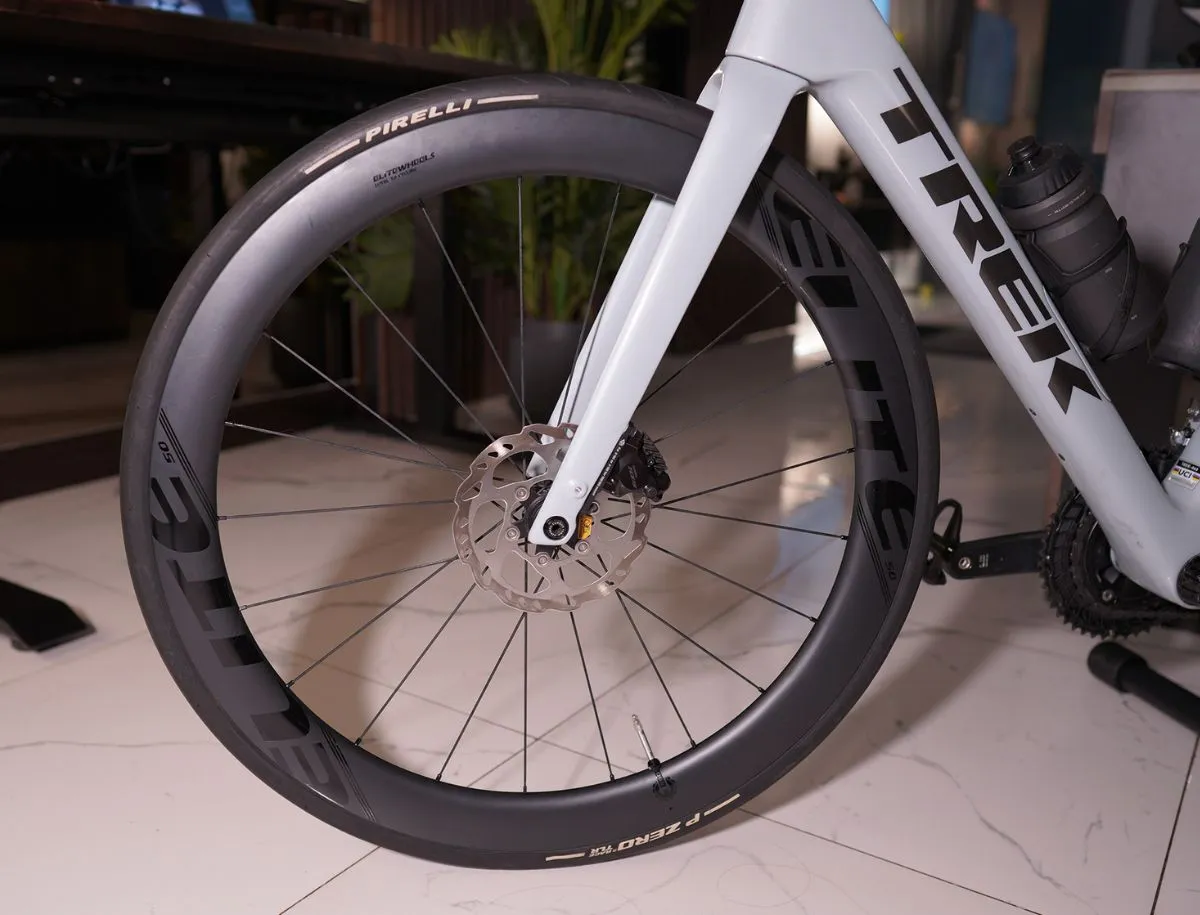 Elitewheels ENT 2.0 carbon front wheel with Pirelli P Zero tire mounted on a Trek Domane SL5 fork, ELITE rim decal visible, disc brake rotor exposed