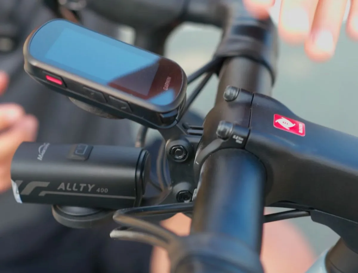 Trek Blendr integrated stem mount showing Garmin cycling computer positioned flush above Magicshine Allty 400 front light on Trek Domane SL5 handlebar