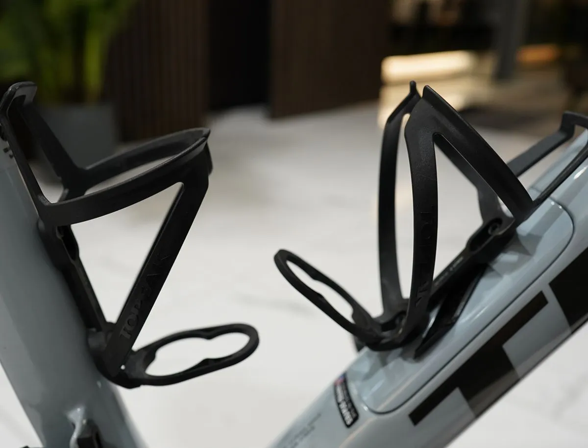 Close-up of two Topeak Ninja Cage Z bottle cages mounted on a road bike, showing the reinforced lip that locks into the Topeak water bottle's security indent part of BikeLabHQ's hands-on testing of the combo.