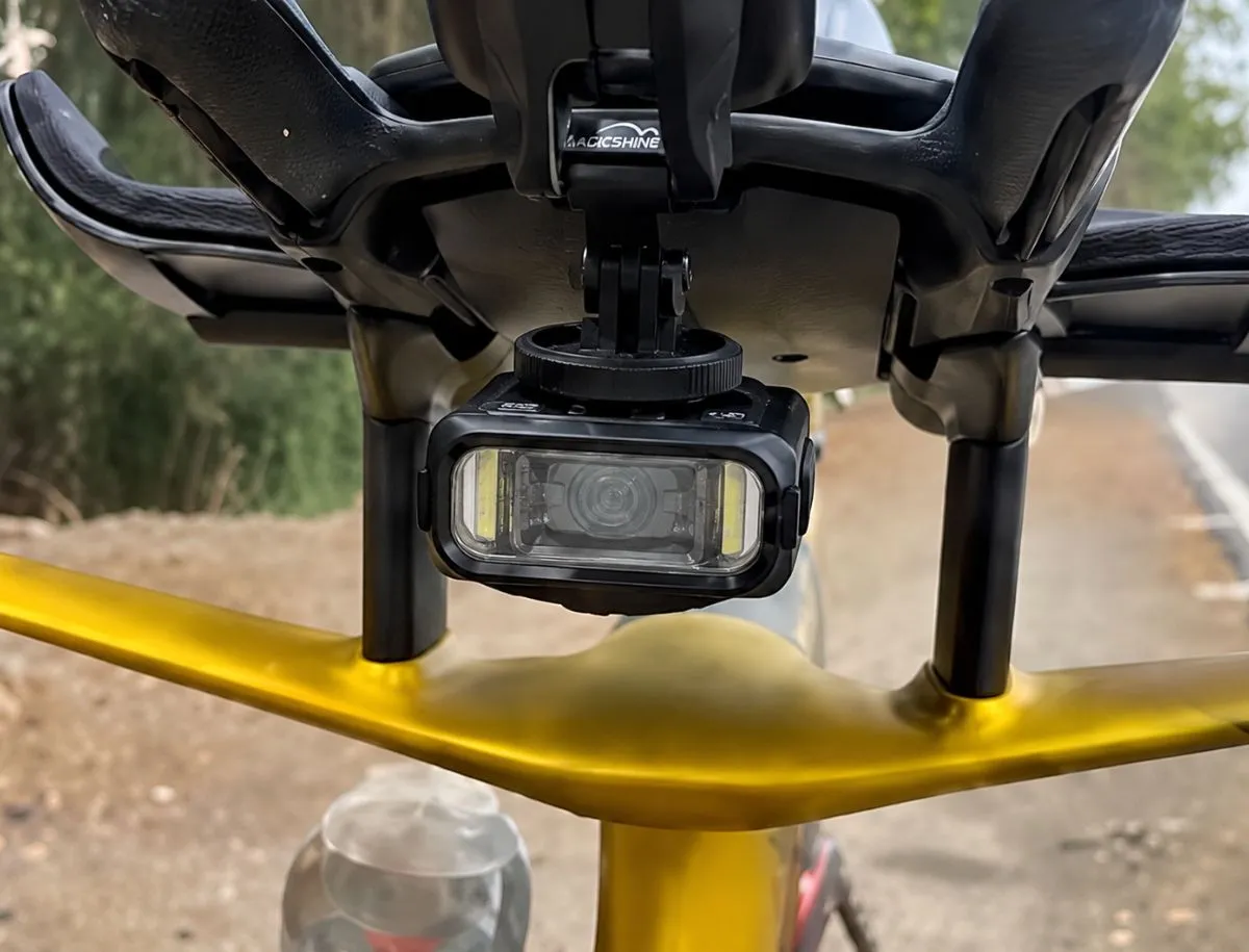 Magicshine HORI 900 bike light mounted underneath a cycling computer
