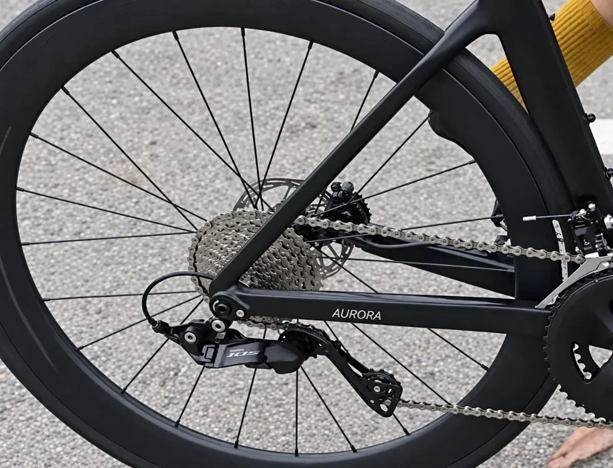Close-up of the Shimano 105 rear derailleur, cassette and carbon rear wheel on the SAVA A7L Pro.