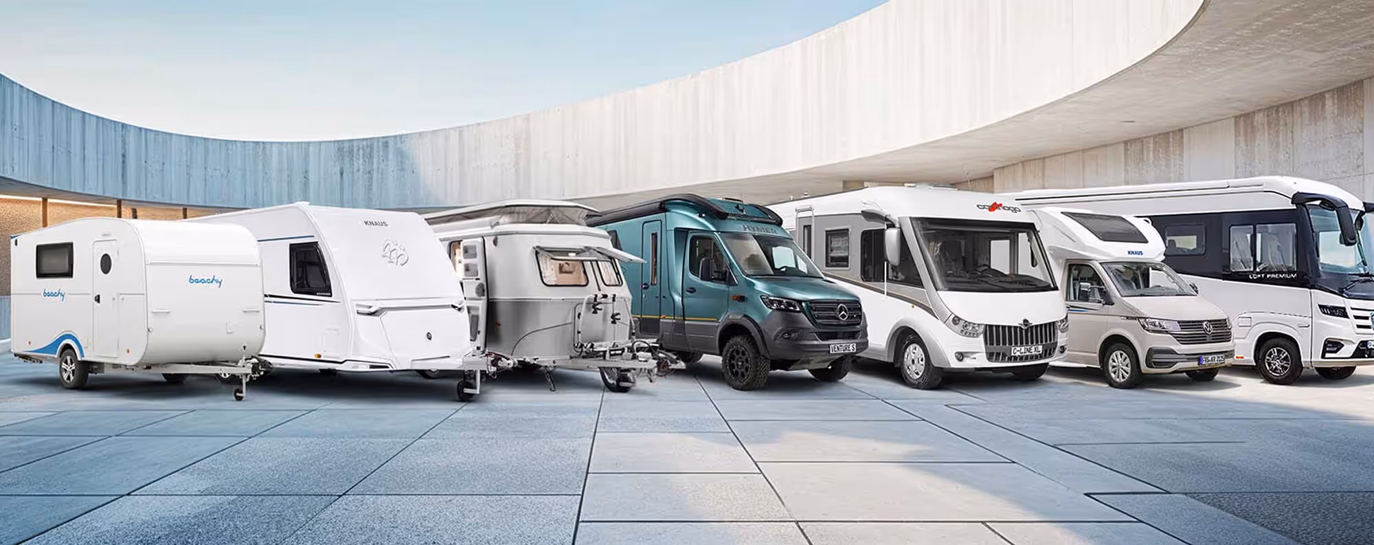 A diverse lineup of modern motorhomes and travel trailers featuring sleek Euramax coated aluminium exterior paneling.