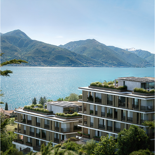 Edifici moderni con giardini sul tetto davanti a un lago e montagne sullo sfondo.