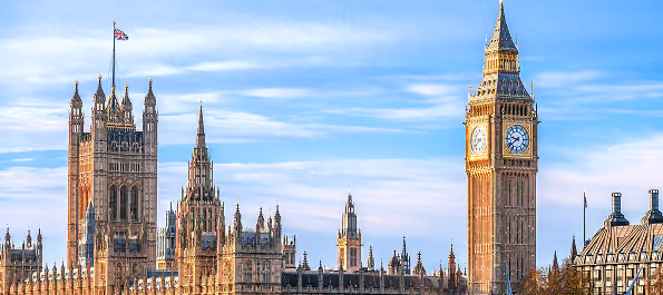 View of London's Houses of Parliament and Big Ben clock tower against a blue sky.