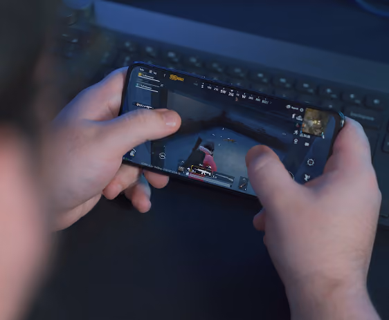 Person holding a smartphone playing a first-person shooter game
