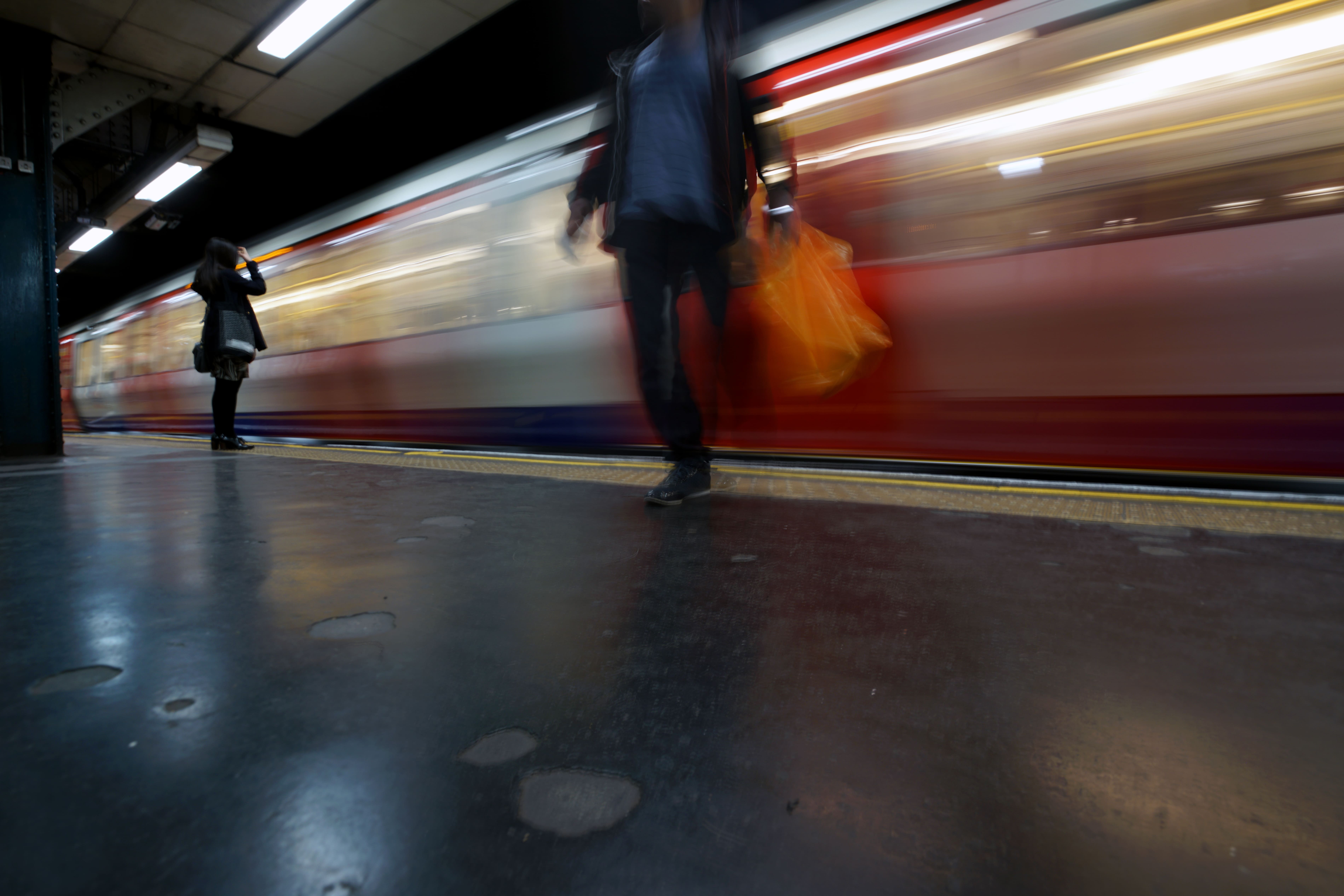 Blurred London Underground train arriving at a station platform.