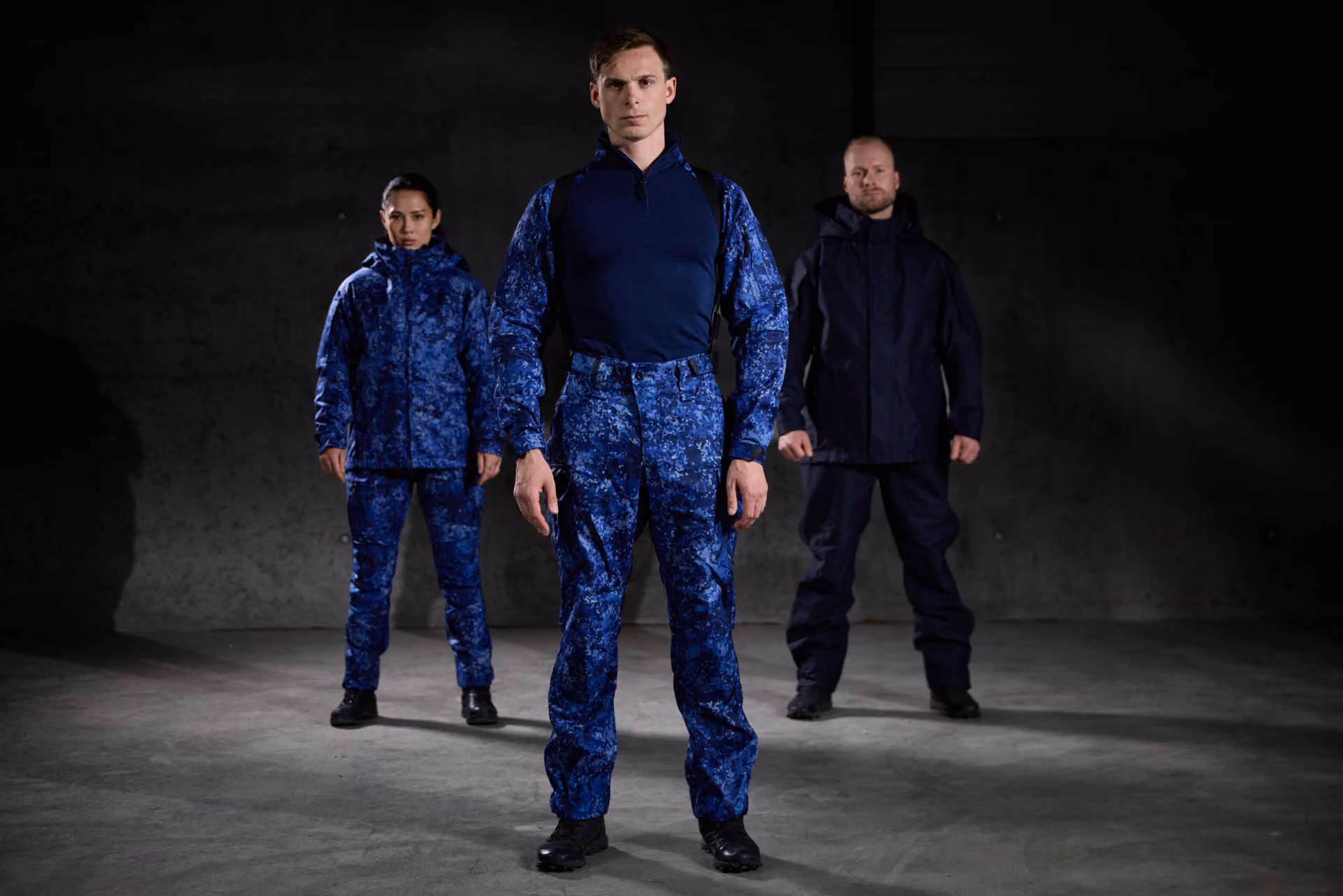 Drei Personen in blauer und dunkelblauer GARM™ Einsatzbekleidung.