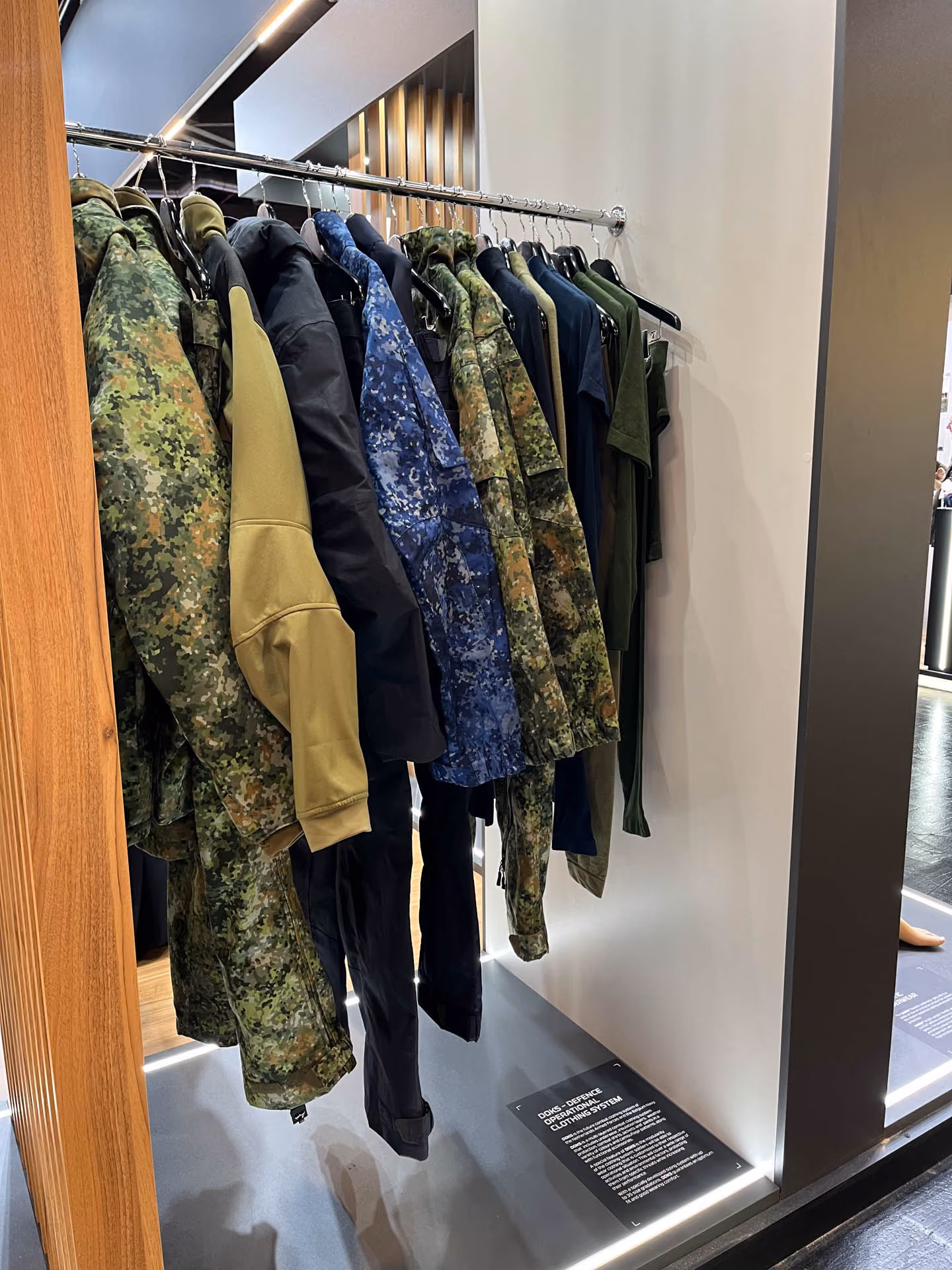 Verschiedene militärische Jacken hängen auf einem Kleiderständer.