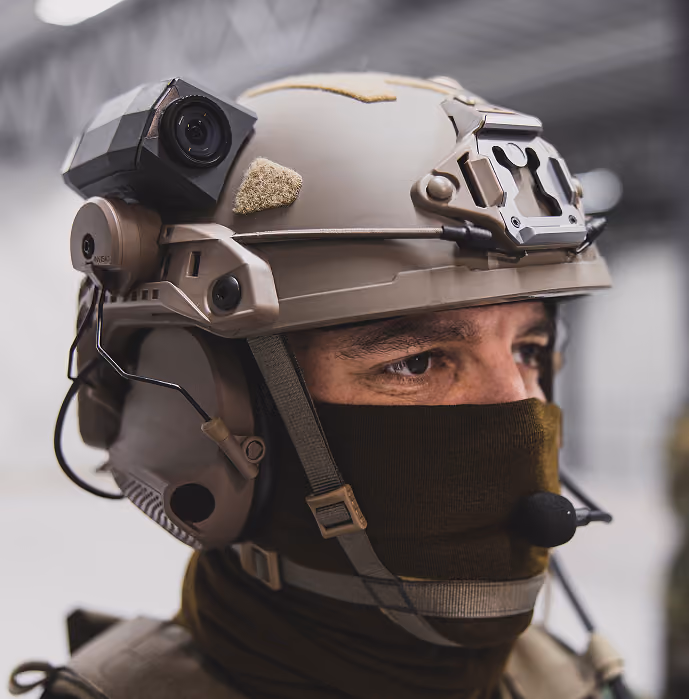 Nahaufnahme eines Soldaten mit sandfarbenem Gefechtshelm und Sprechgarnitur.