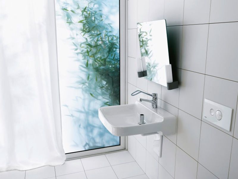 Ein unterfahrbares Waschbecken mit barrierereduzierten Armaturen und kippbarem Spiegel.