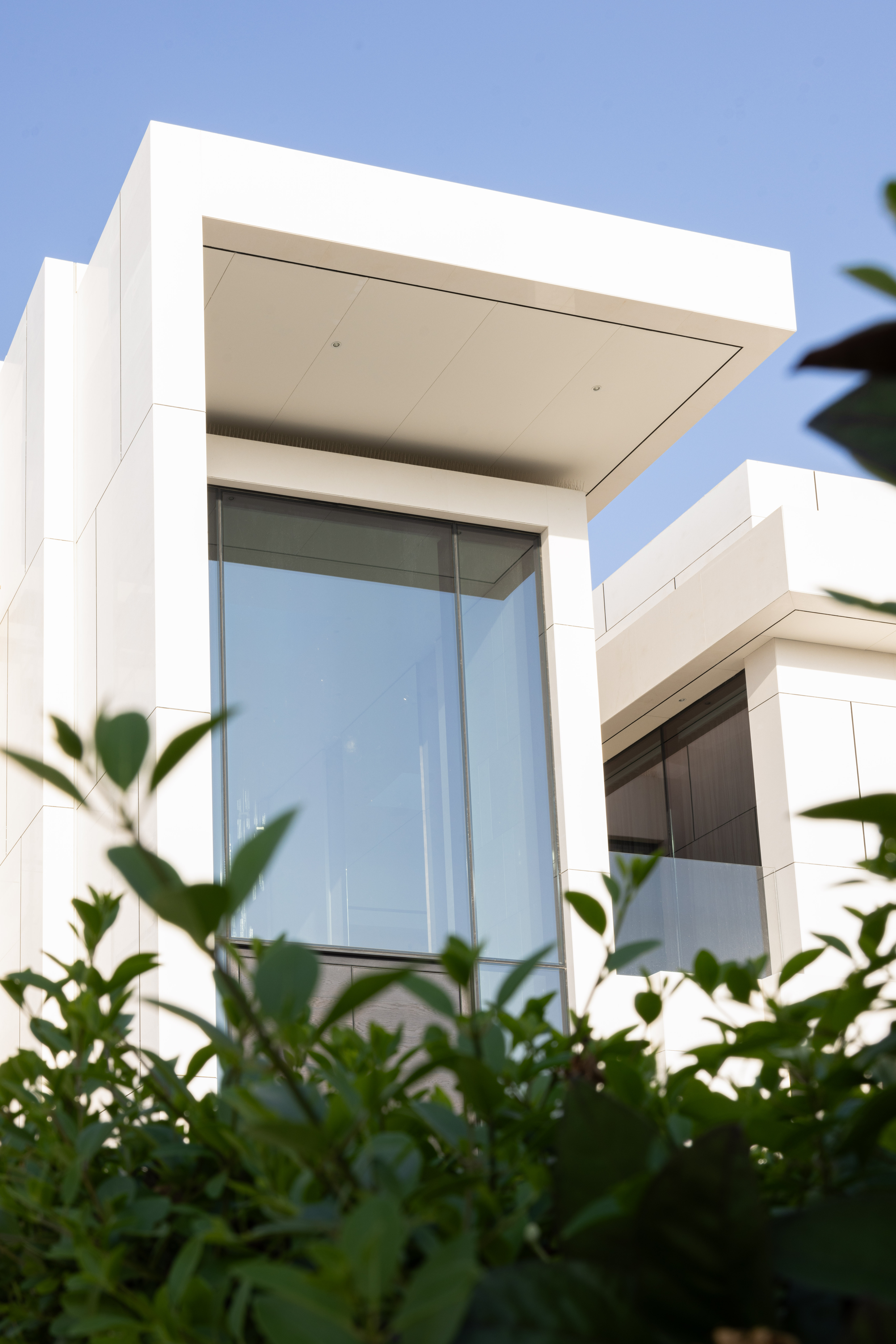 Modern white cantilevered villa exterior by Emkaan