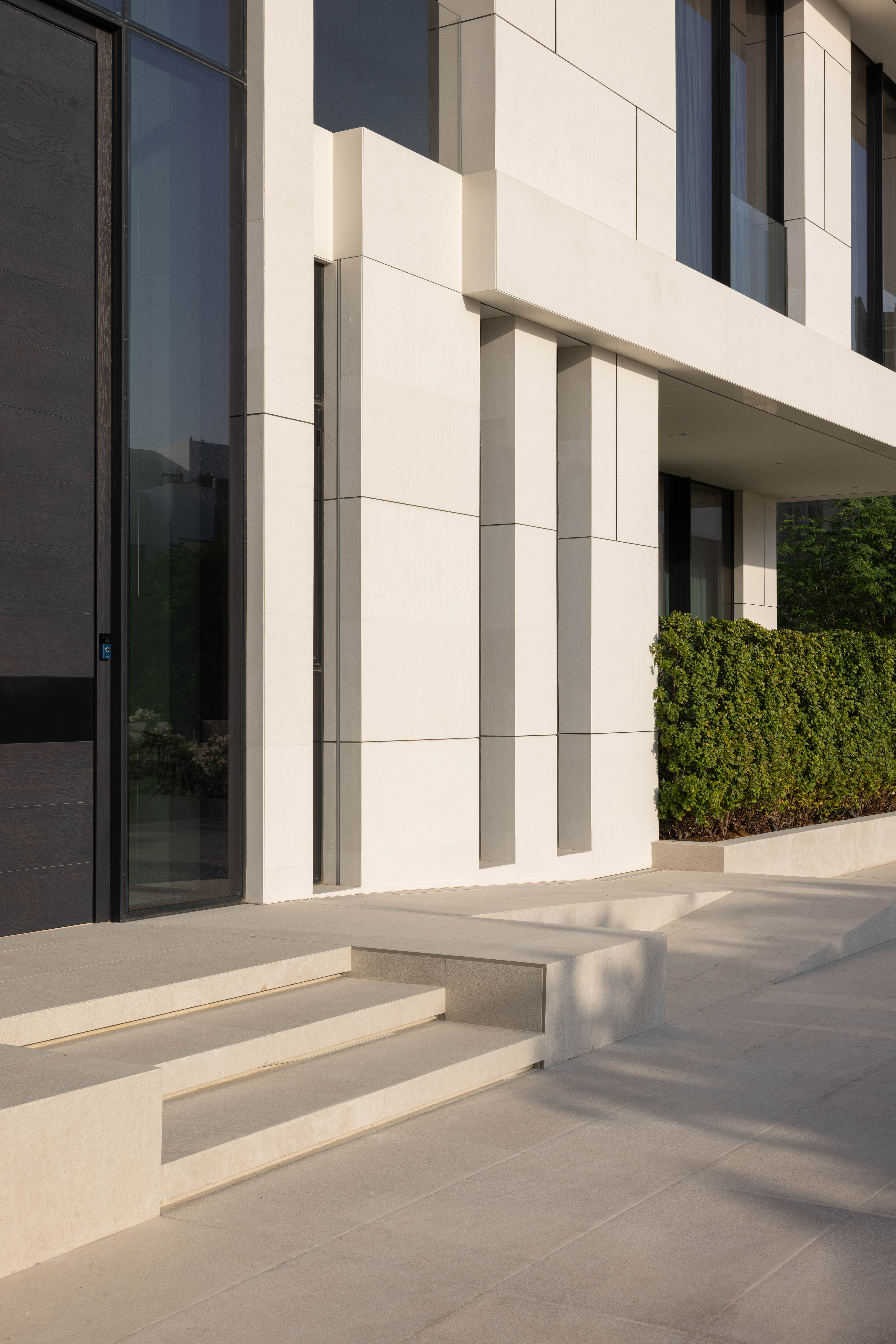 Contemporary building facade with stone steps by Emkaan