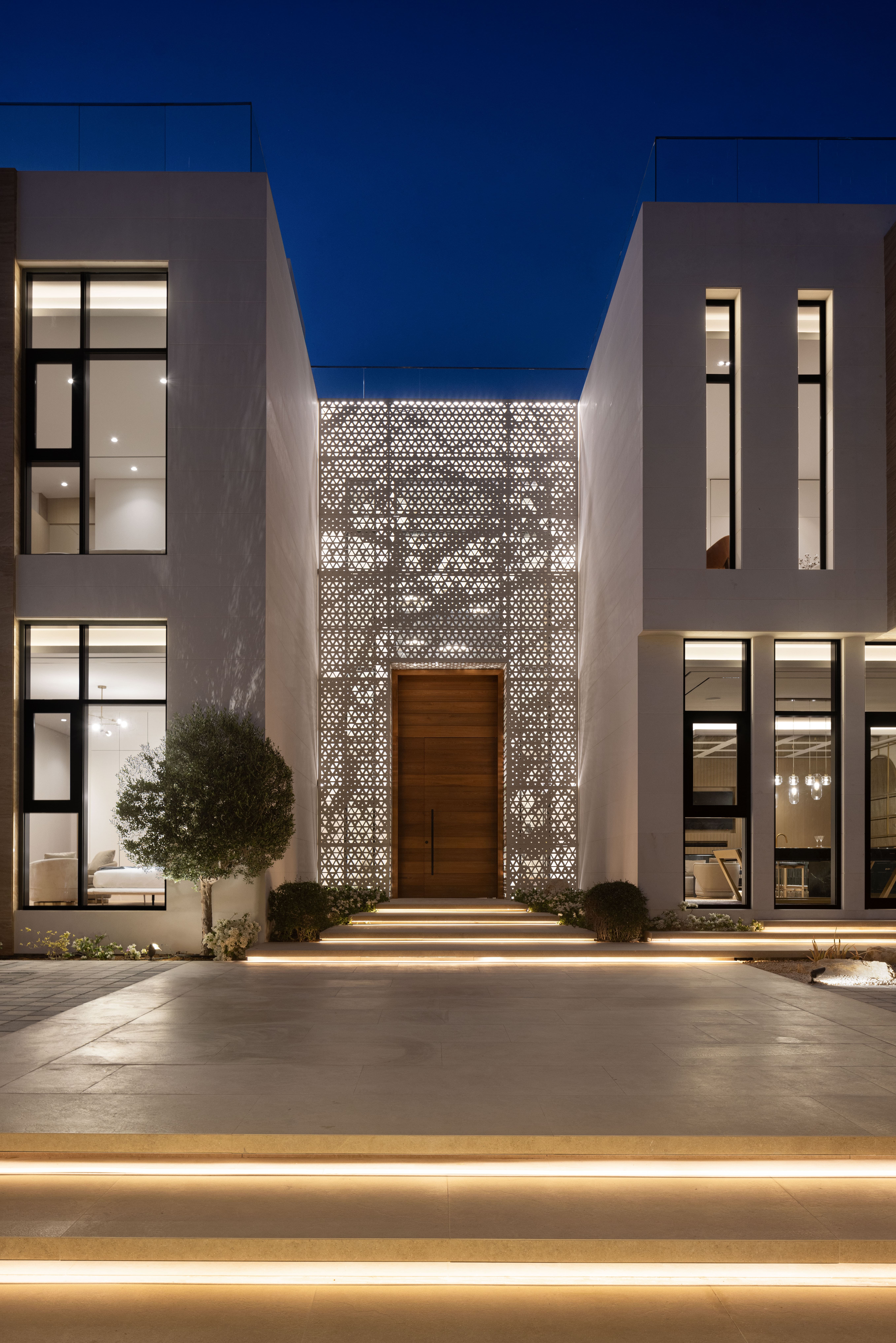 Modern villa exterior illuminated at dusk by Emkaan