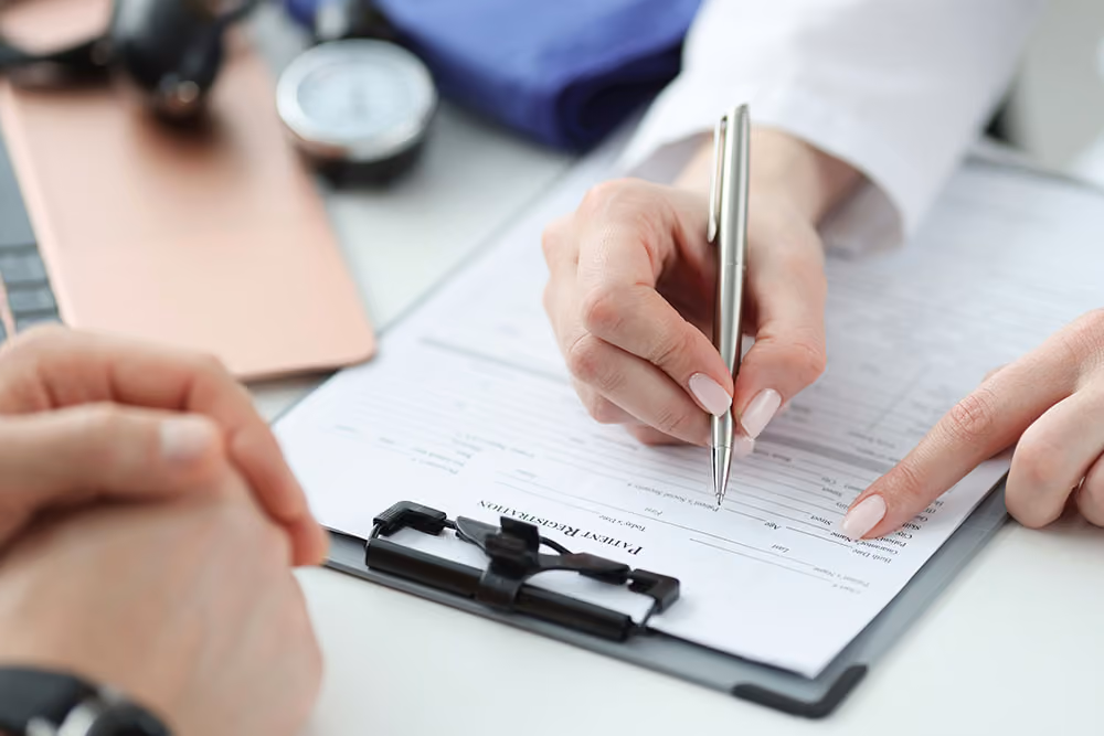 Hand met pen wijst op formulier op clipboard terwijl andere handen gespannen zijn.