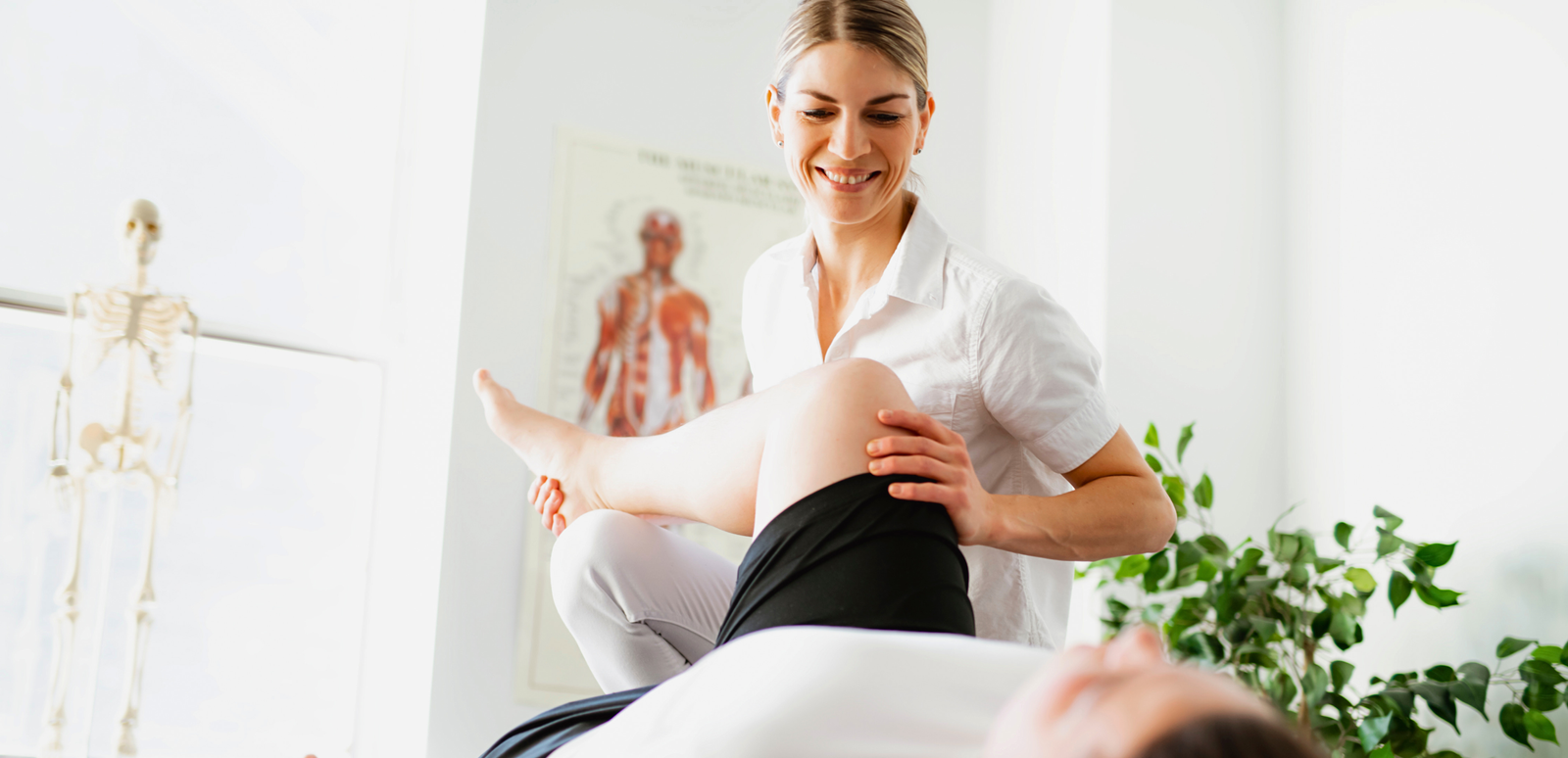 Therapeutin mit Patient in einem Behandlungsraum einer Reha-Klinik