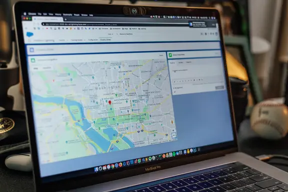 MacBook Pro laptop showing a map with location markers and a side panel with user comments.