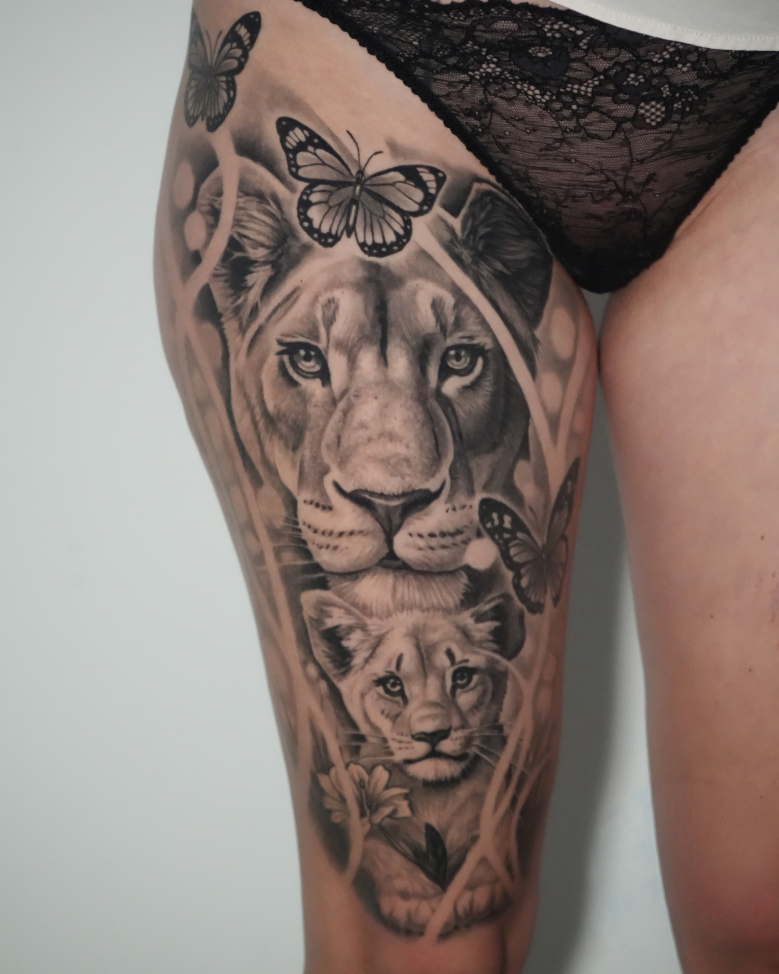 Lion family tattoo in black and grey realism by Raza Tattoo in Aarhus 