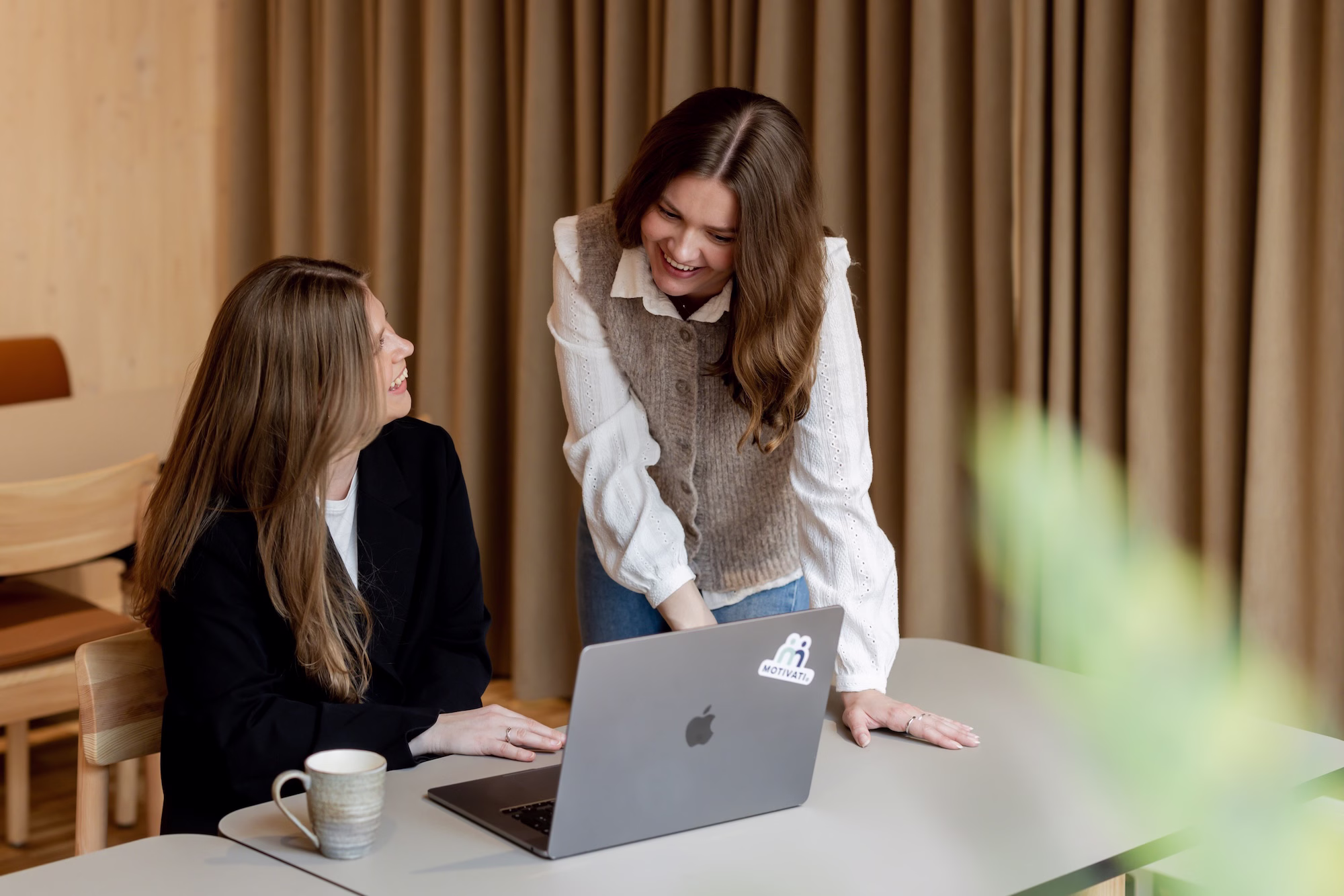 Eirin and Pernille from Motivati are looking at a computer and smiling