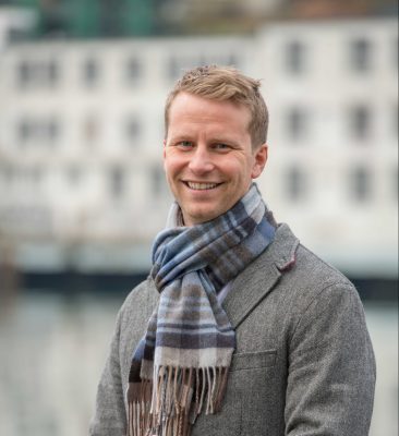 Mads Nordmo Arnestad is wearing a scarf and smiling to the camera