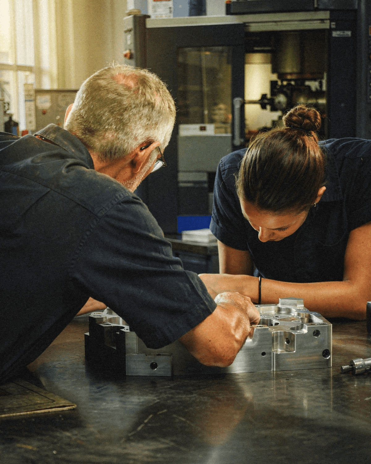A leadership team in conversation in an industrial workplace.