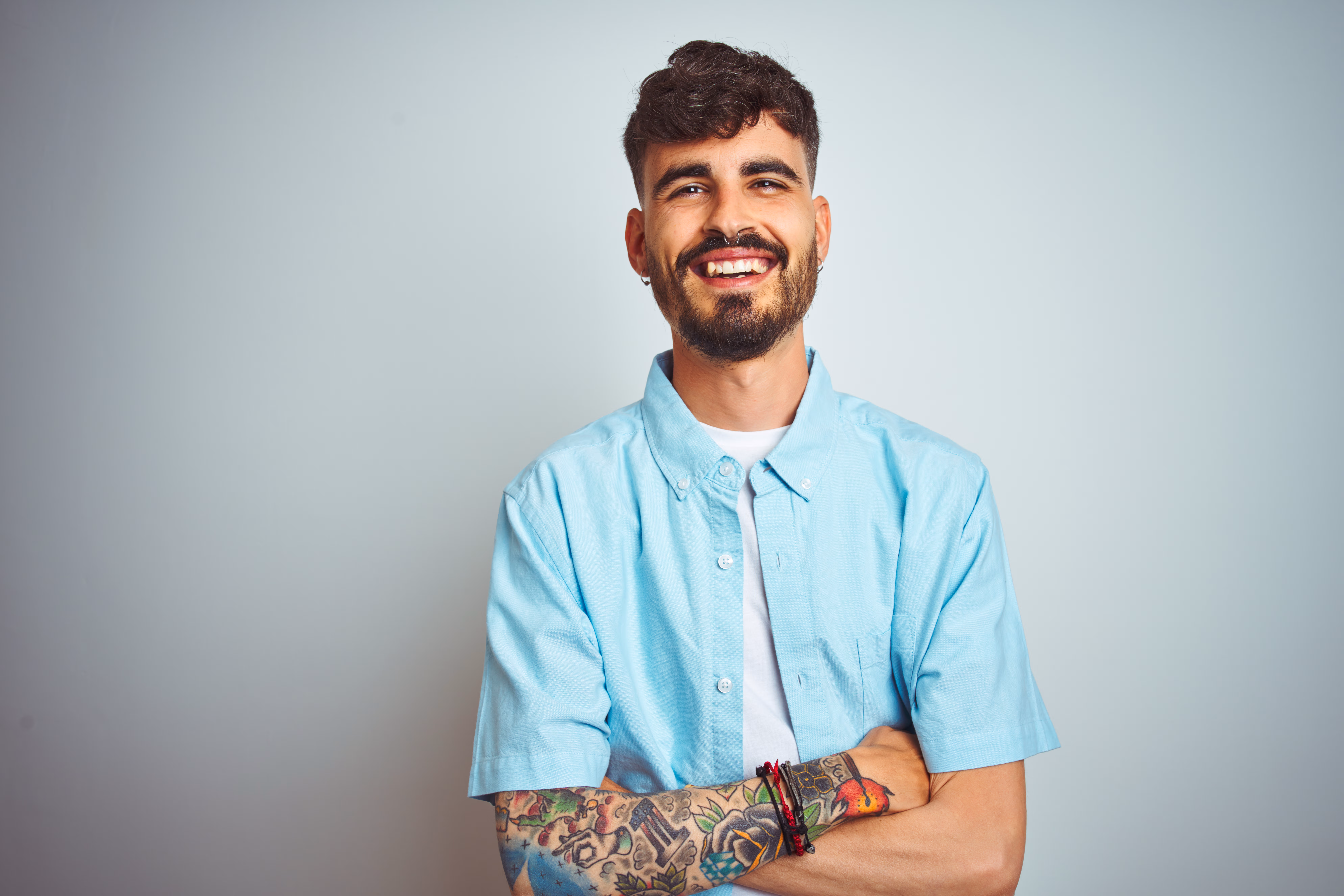 A man smiling with his arms crossed