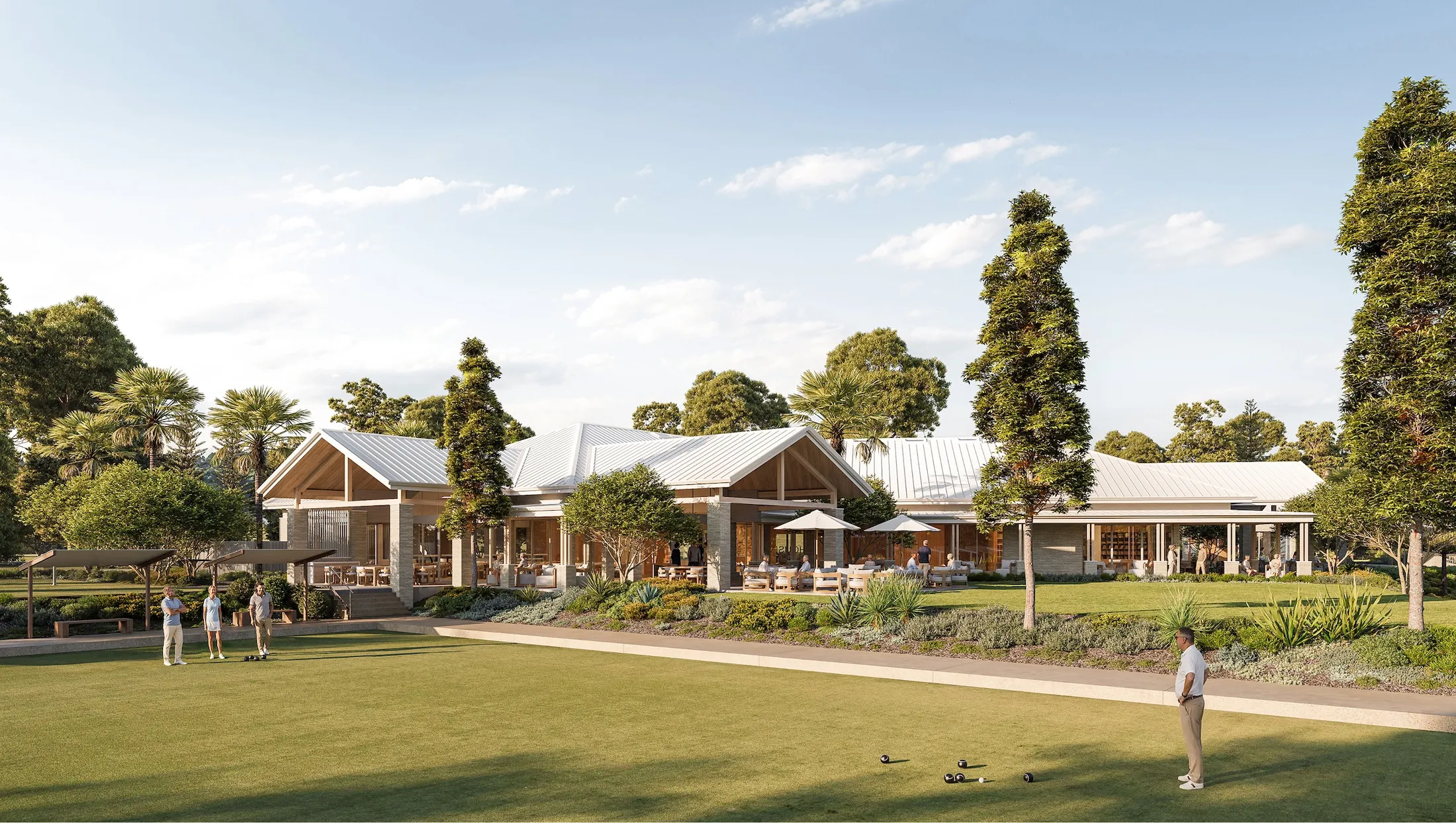 People playing lawn bowls on a green in front of a modern clubhouse with white roof and trees around.