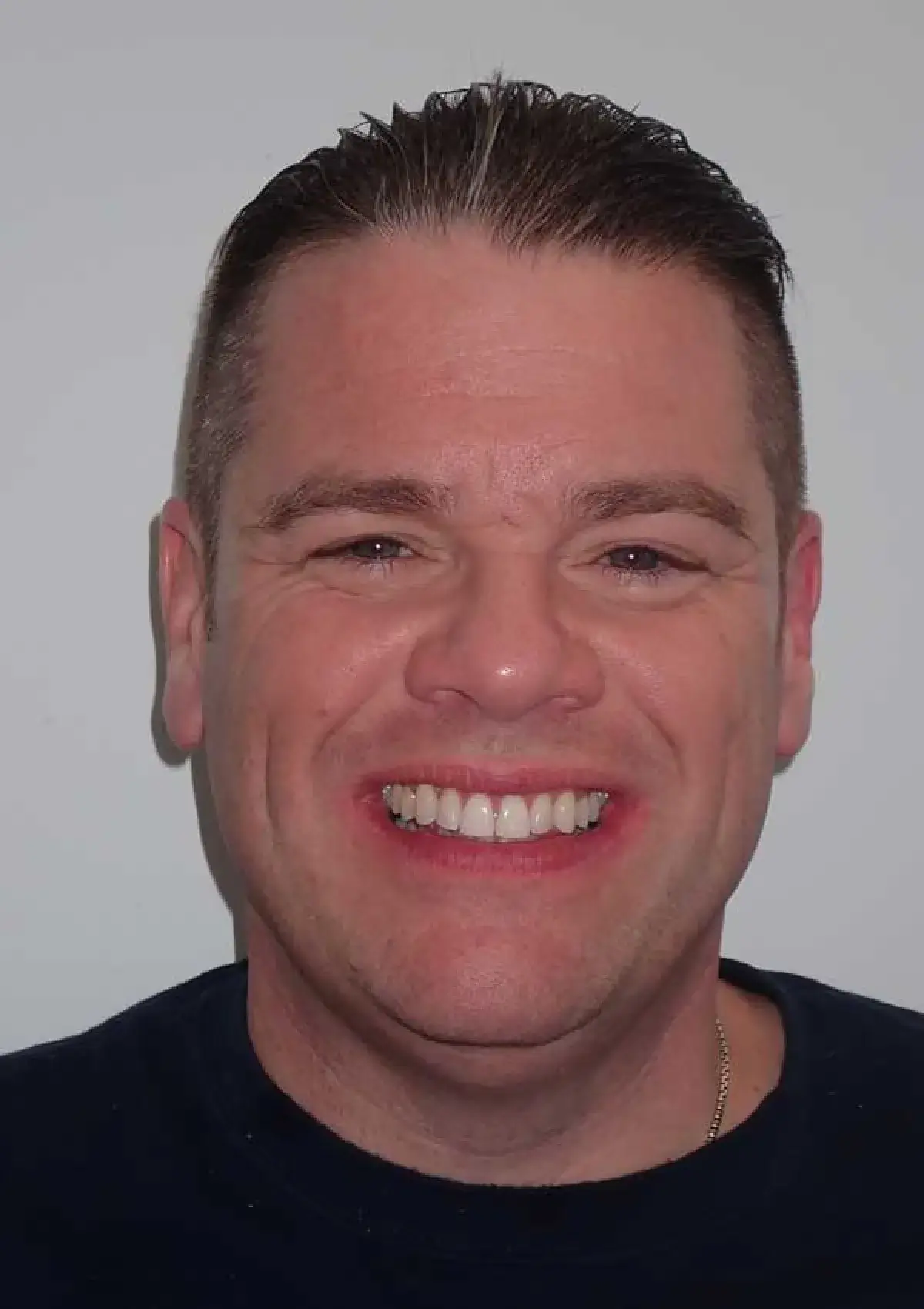 Man smiling at the camera against a plain white background.