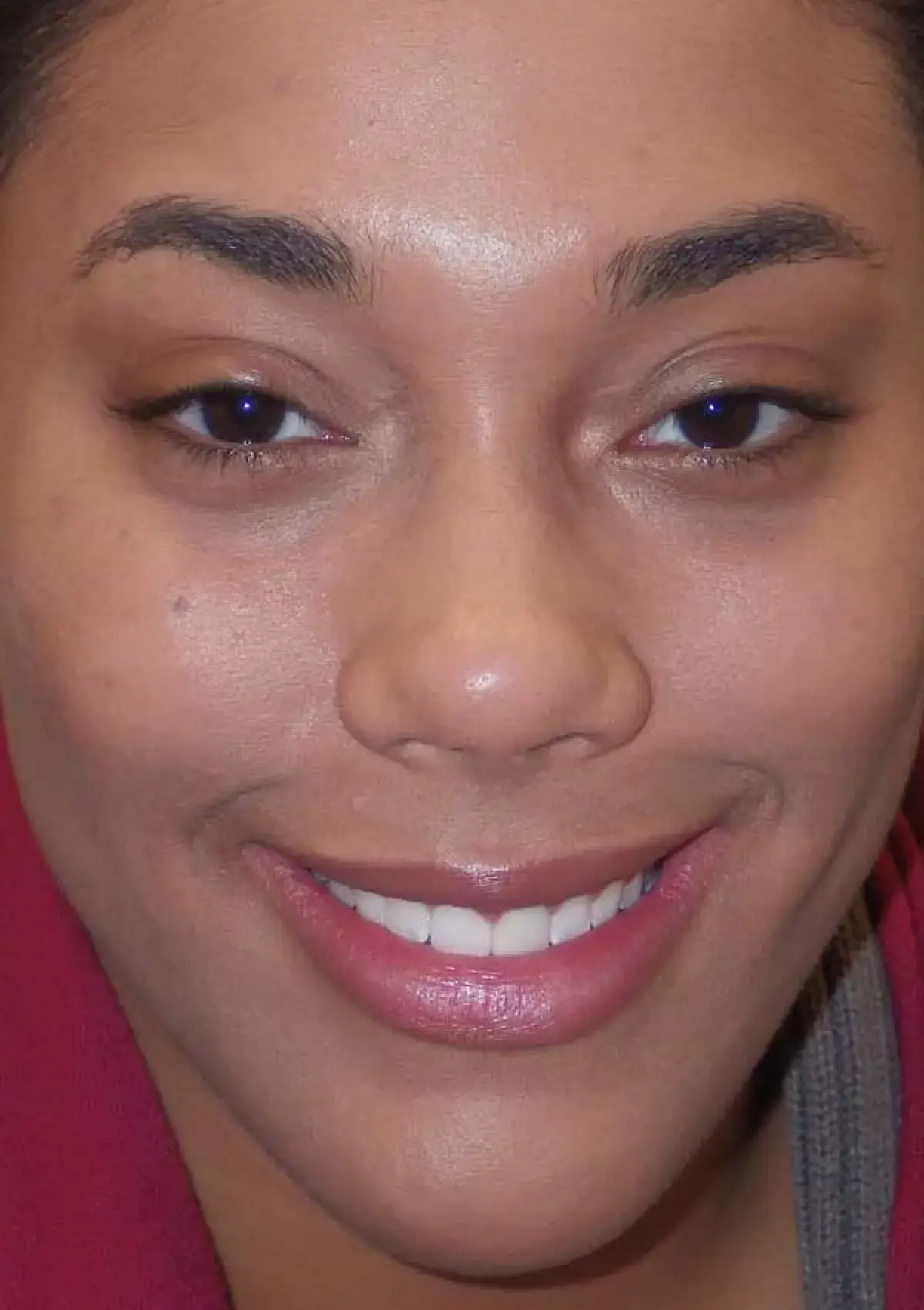 A person smiling directly at the camera, showing teeth.