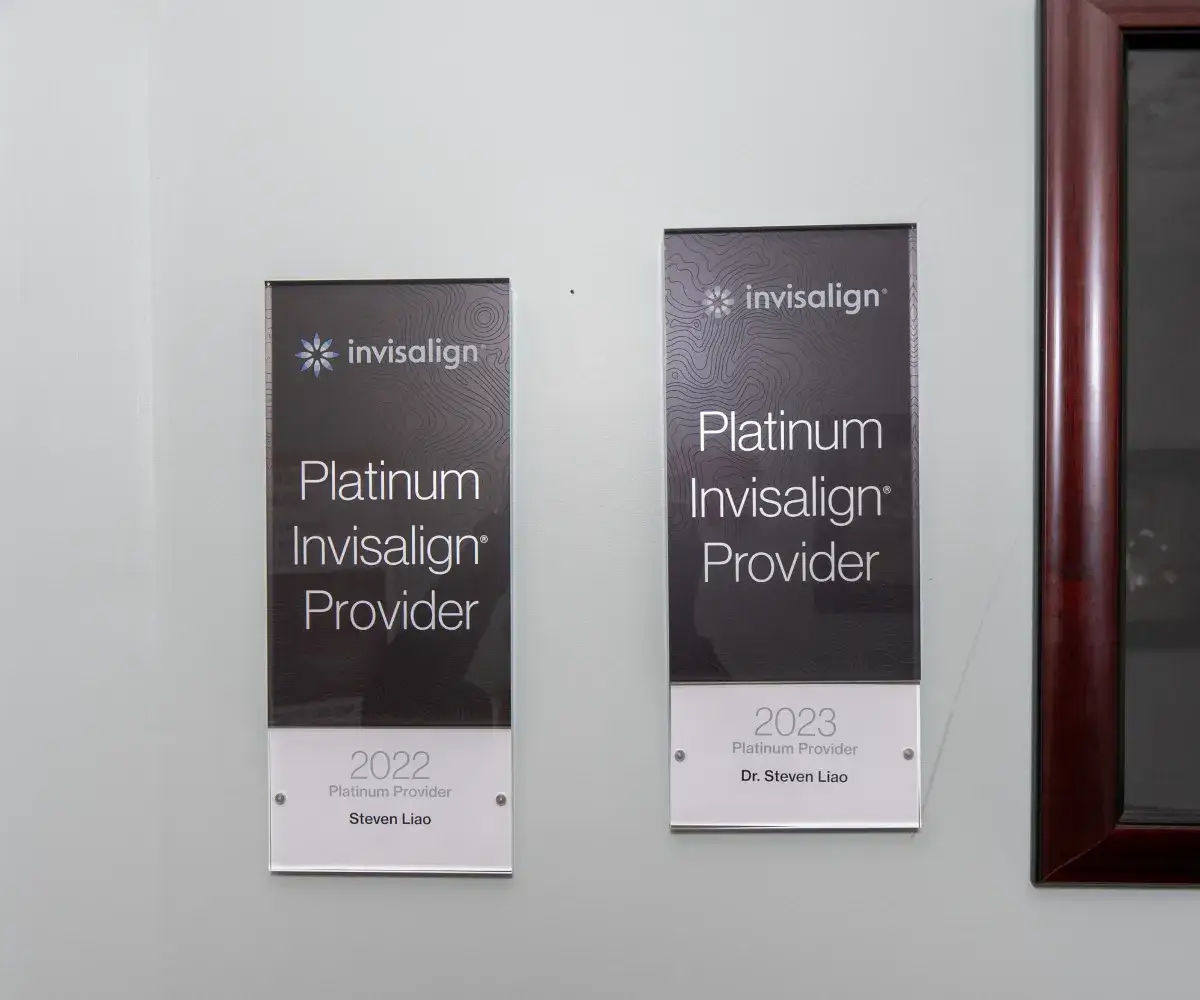 Two plaques on a wall recognize Invisalign Platinum Provider achievements for 2022 and 2023.