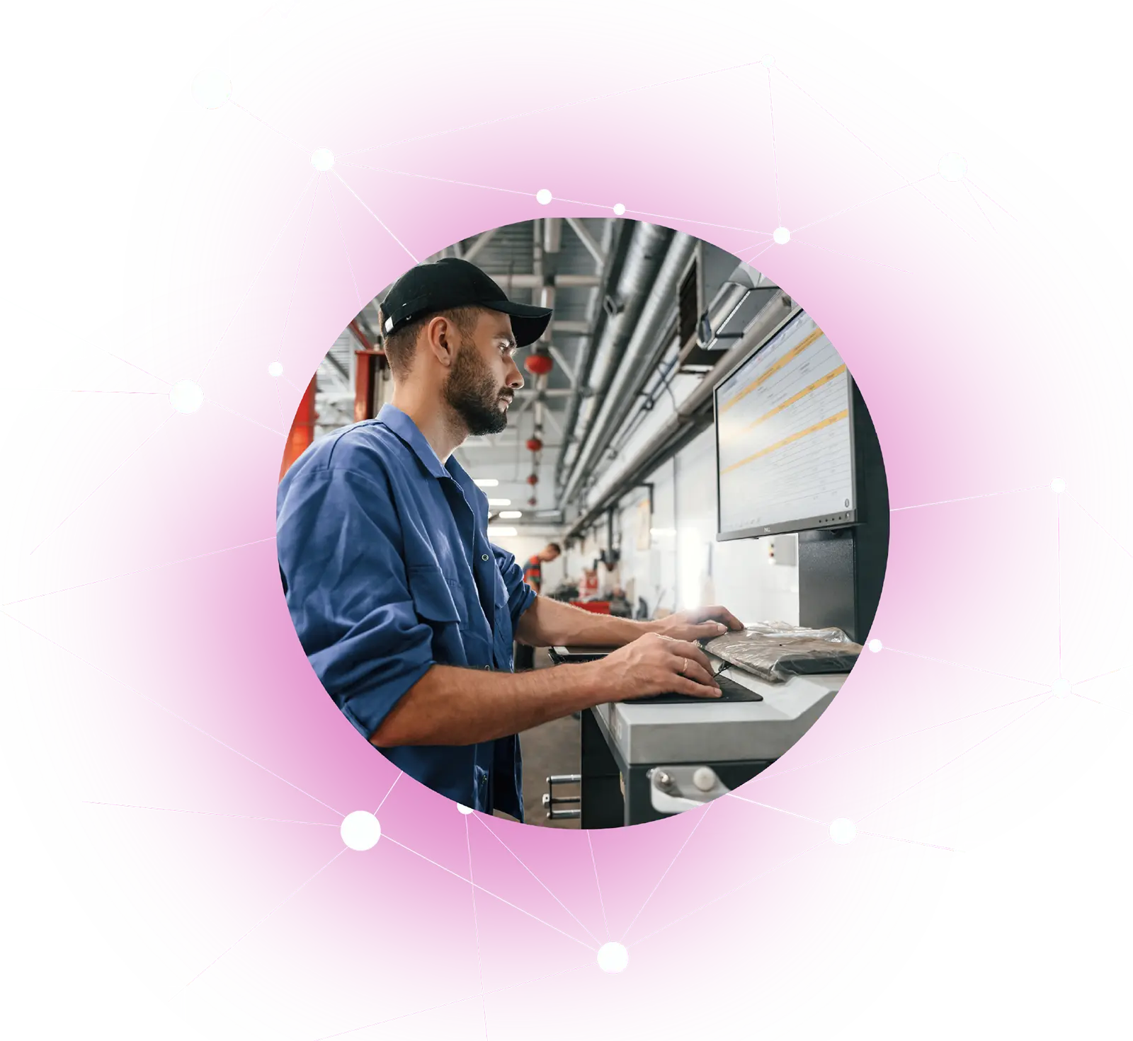 Man in blue workwear using computer in an industrial or factory setting.