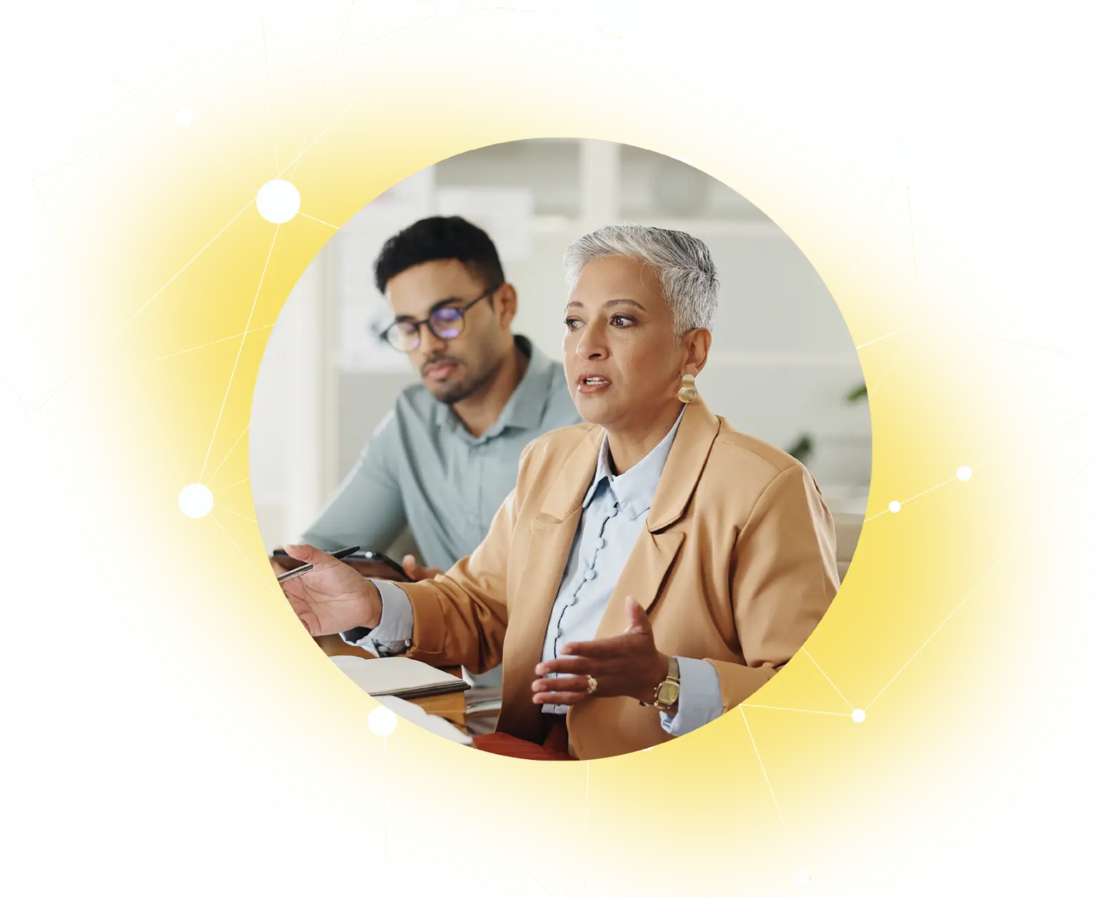 Two professionals discussing work, woman explaining with hand gestures, man listening attentively.