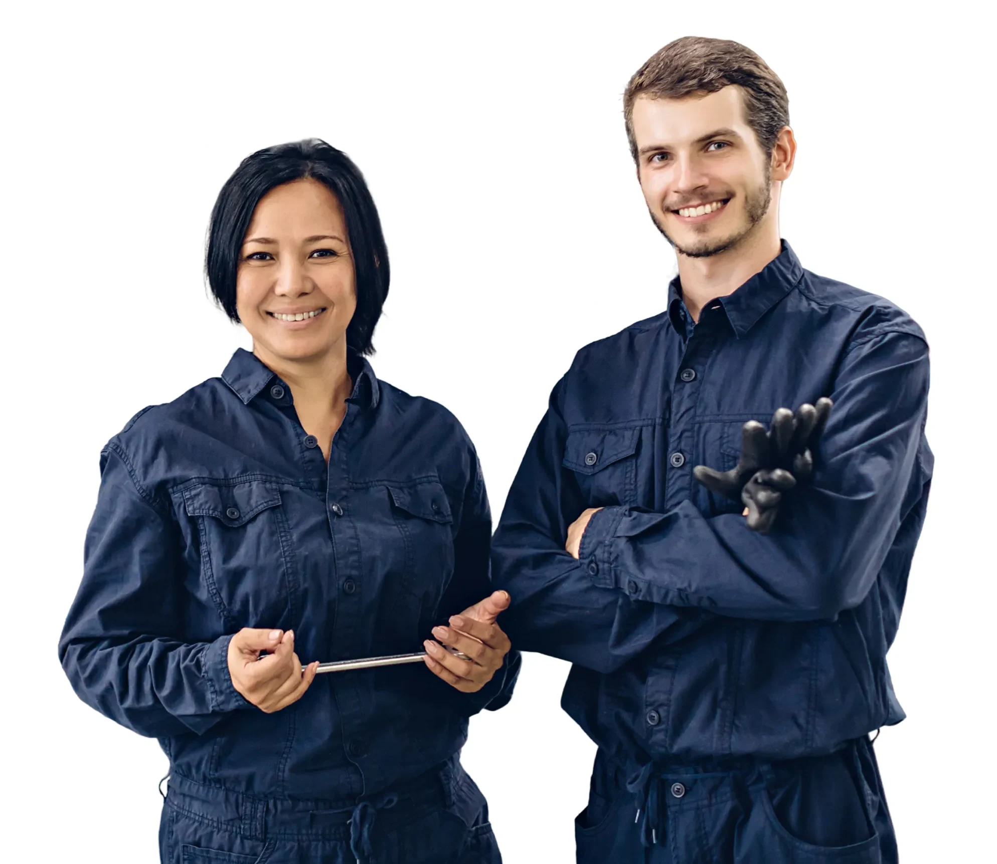 Smiling male and female mechanics in navy coveralls, one holding a tool, the other wearing gloves.