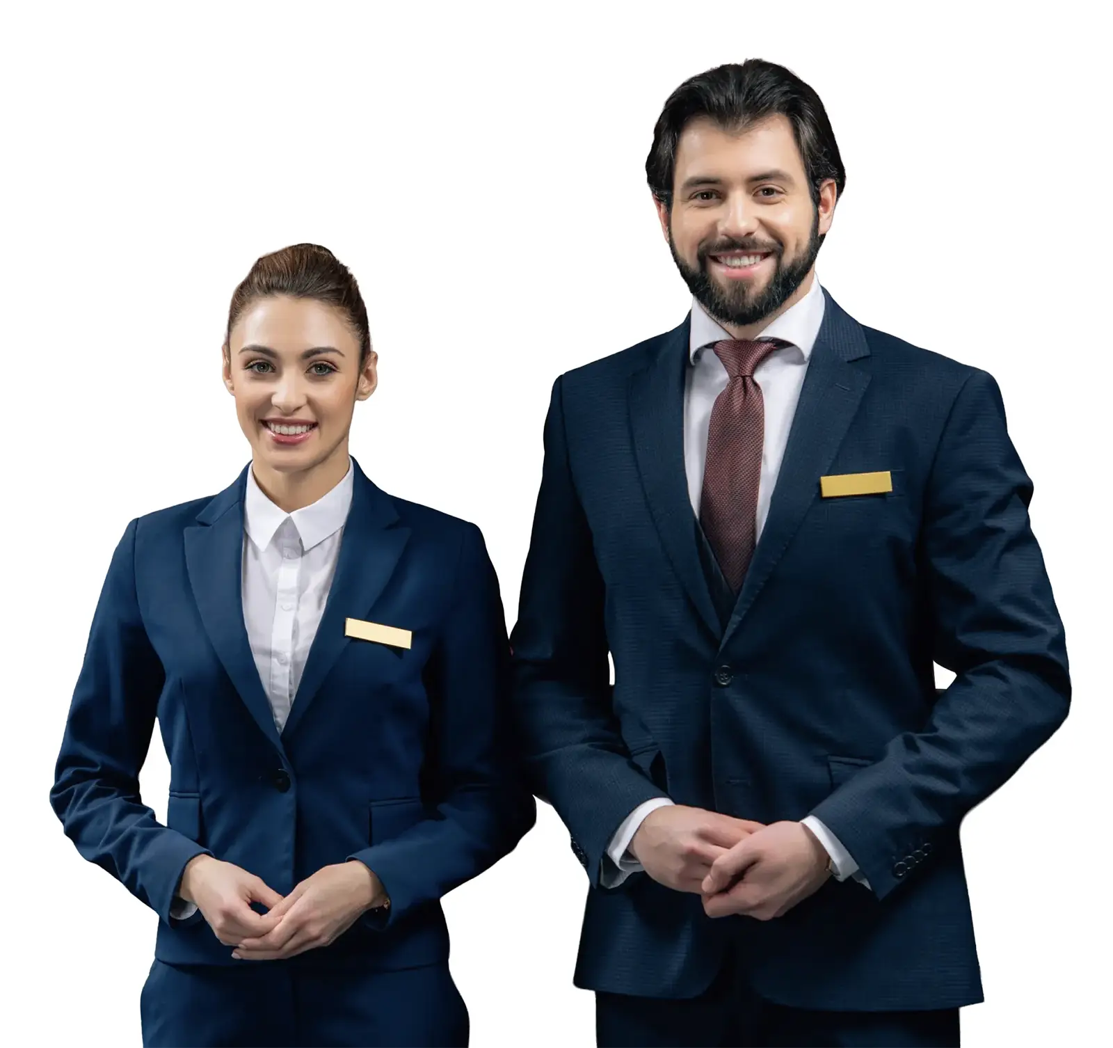 Smiling man and woman in formal navy blue suits with blank name tags standing against white.
