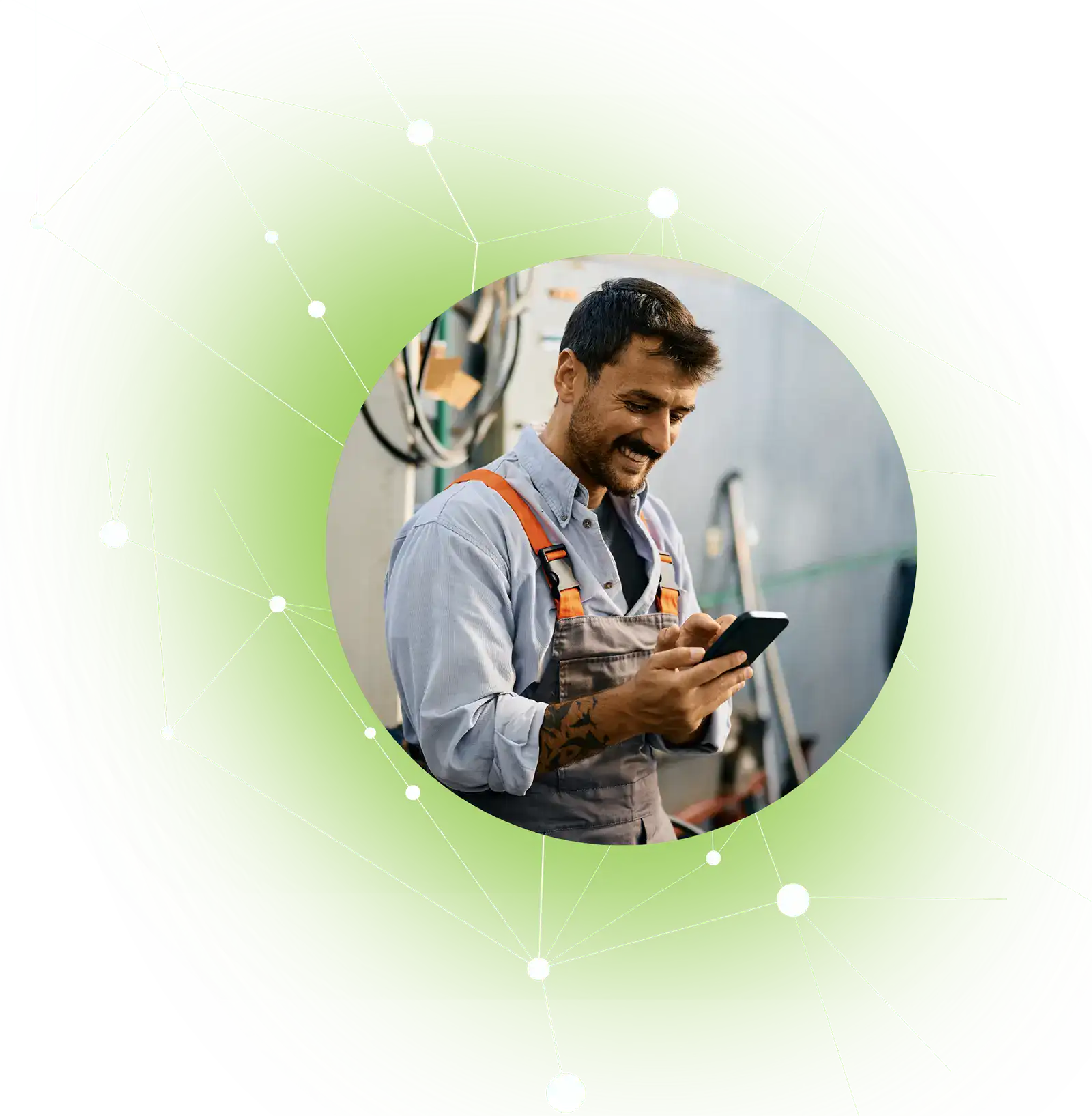 Man in work overalls smiling and using smartphone inside an industrial setting.