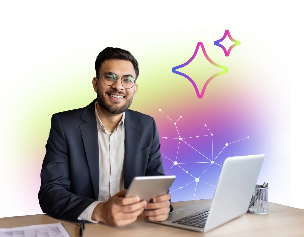 Smiling man in glasses with tablet, sitting at desk with laptop and papers, colorful tech background.