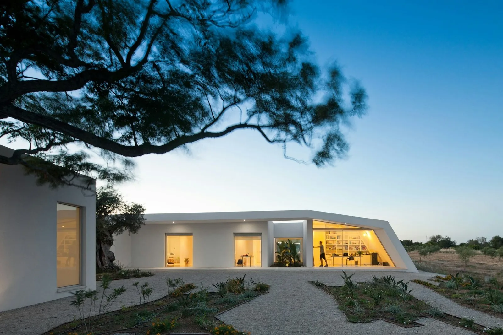 Modern home lit up at dusk after completion