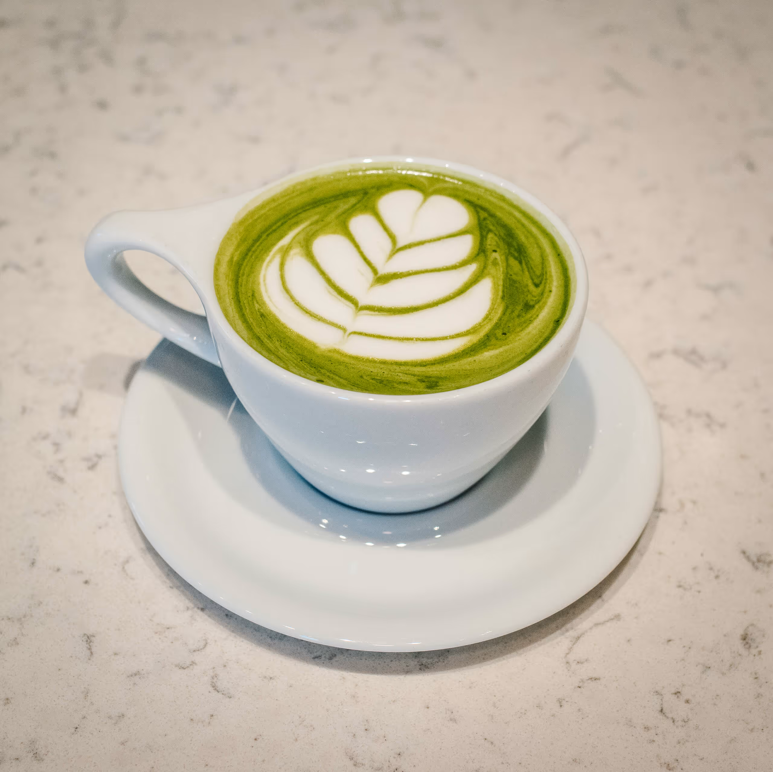 A cup of coffee with a heart shaped foam on top.