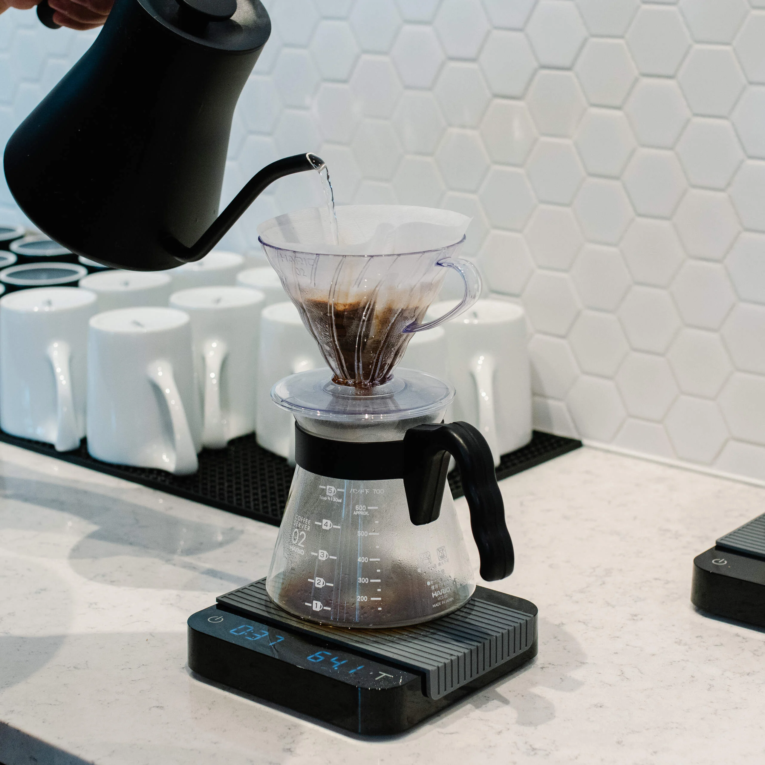 A coffee maker with a glass carafe and a black handle.