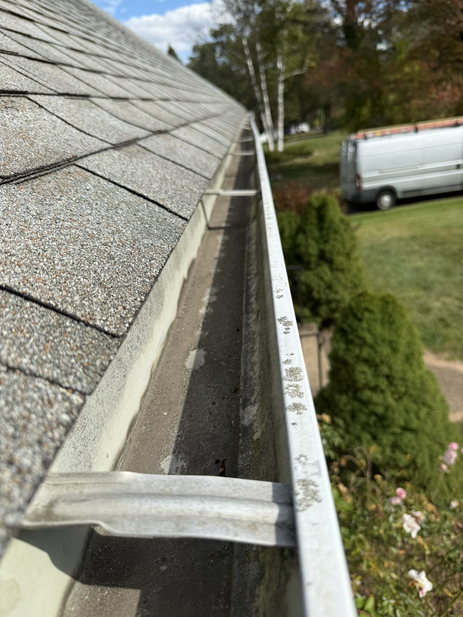 Clean K-style gutters along the roofline of a white-sided home