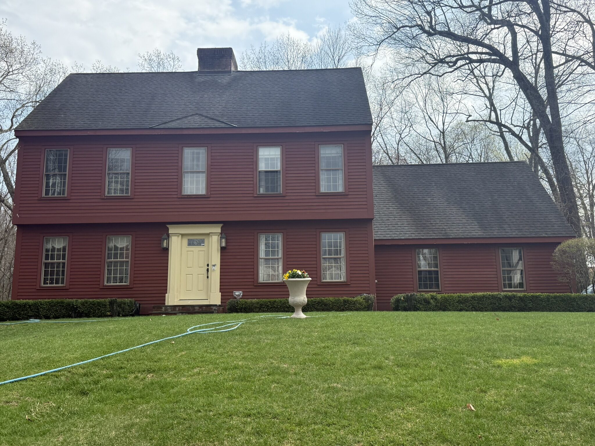 Red colonial home with a yellow door in Bristol, CT