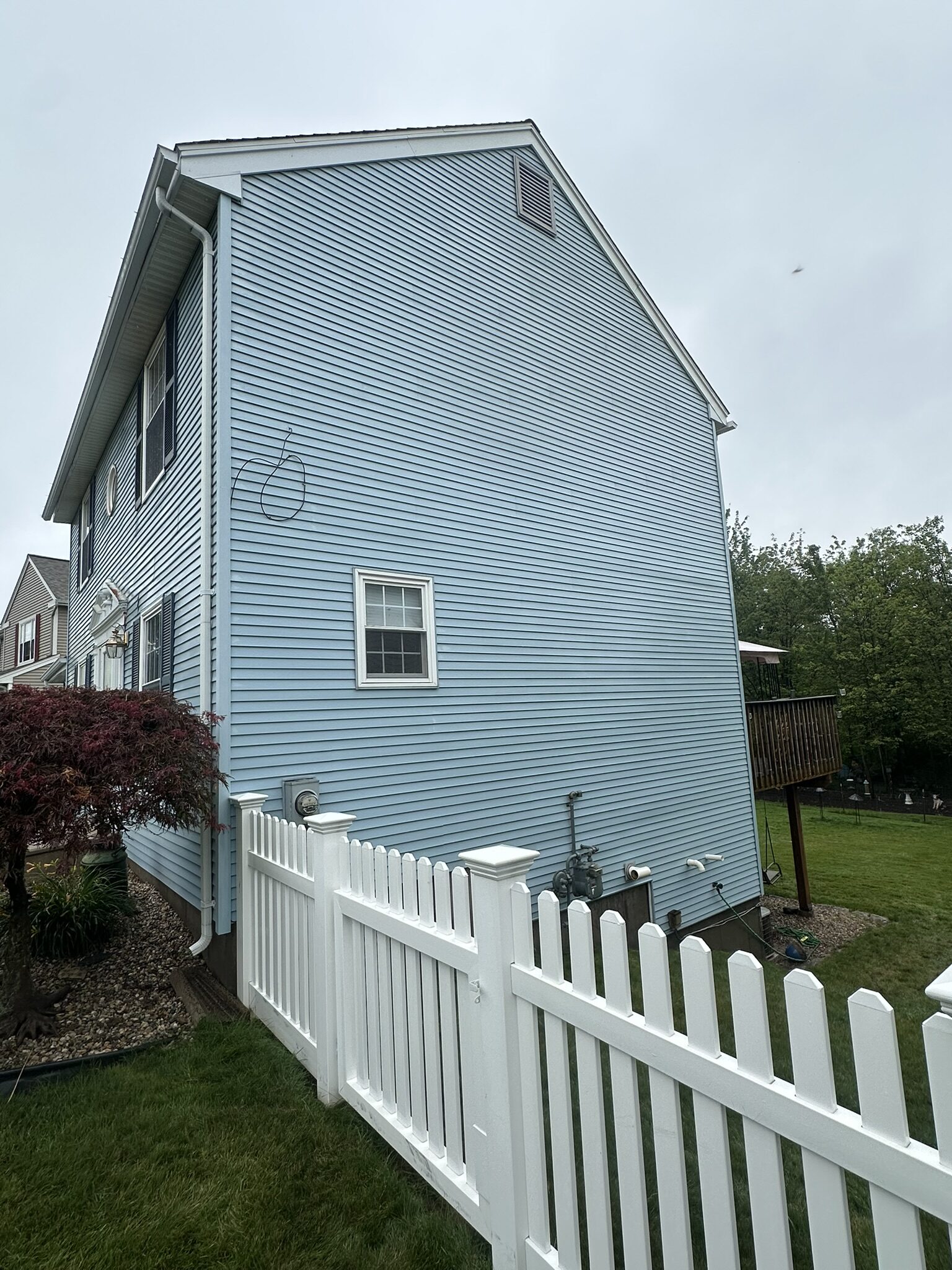 Clean blue gable siding after Eagle's soft wash