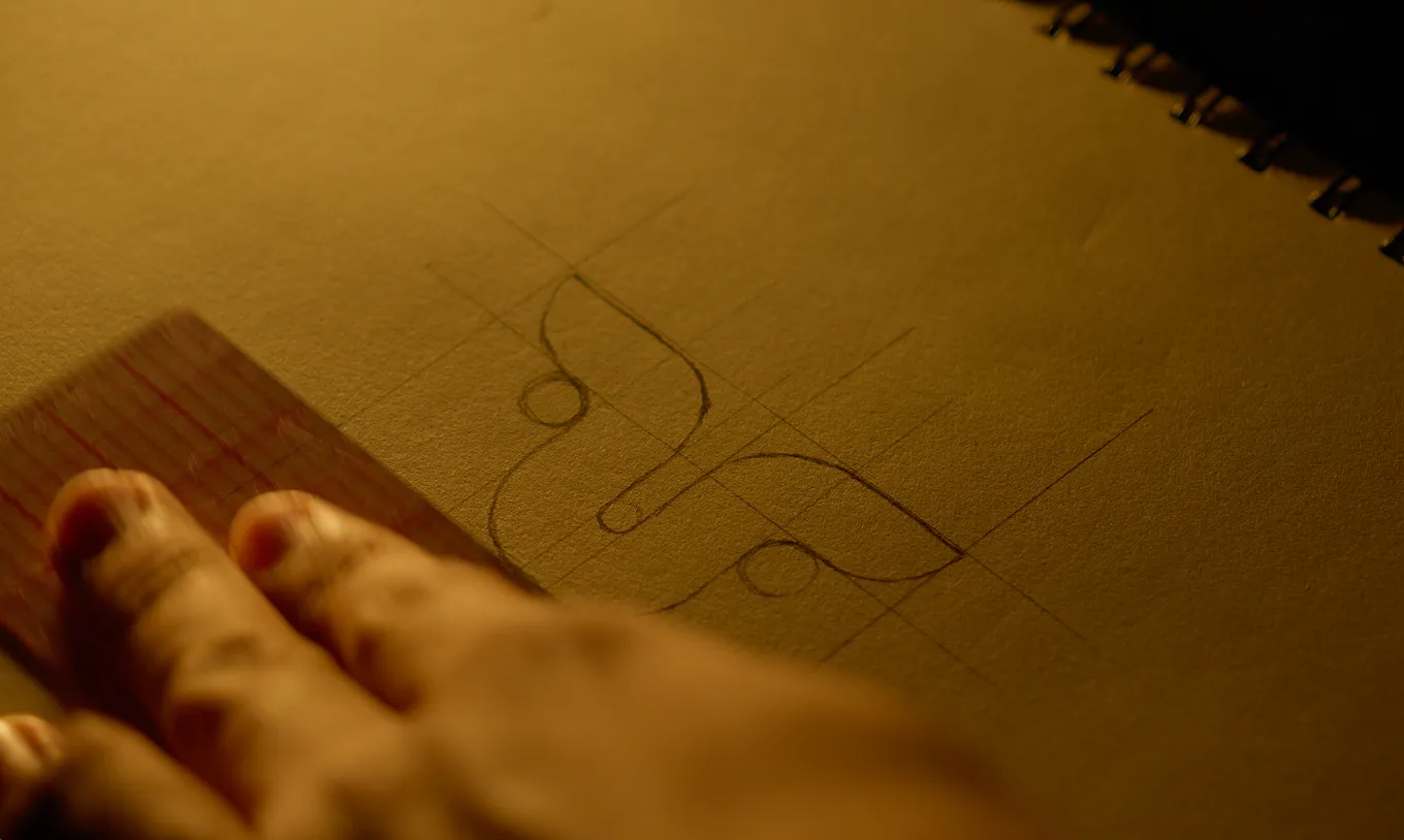 Man sketching the Umbricia brand logo in a notebook.