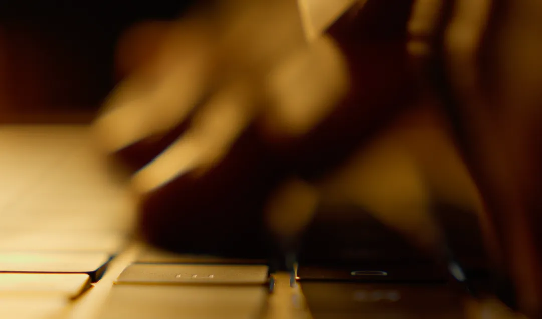 Man typing on a laptop with intensity, ideas forming through the keyboard.