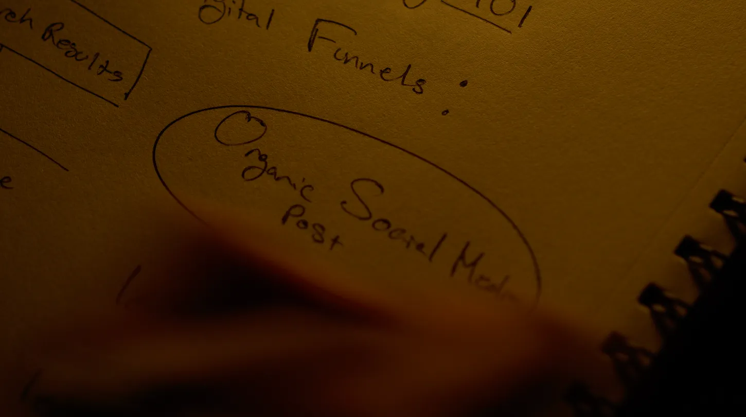 Man circling ideas on a notebook while brainstorming marketing strategy.