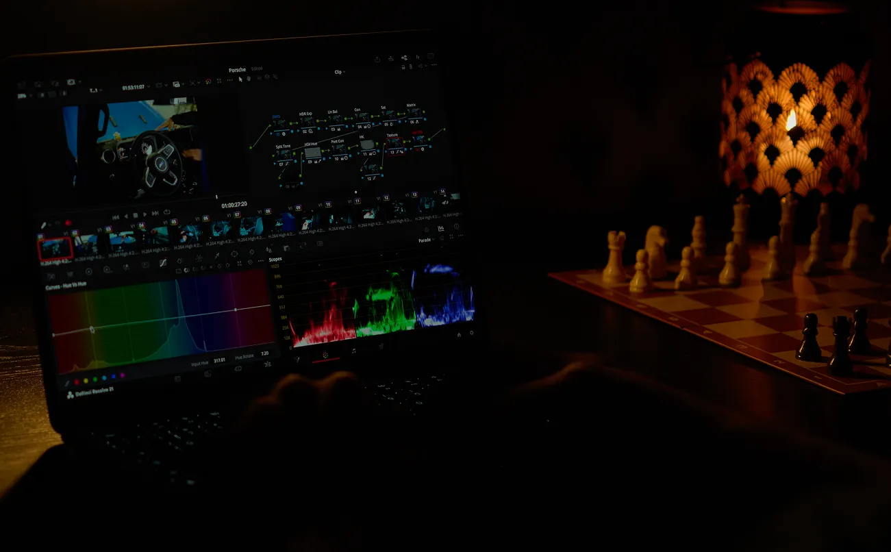 Man colour grading a video for content on his laptop utilizing davinci resolve. 