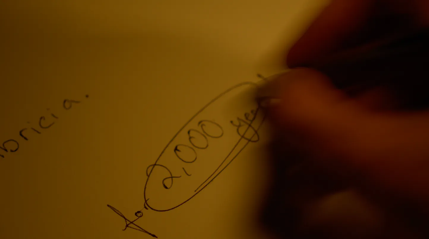 Man circling important text on a notebook.