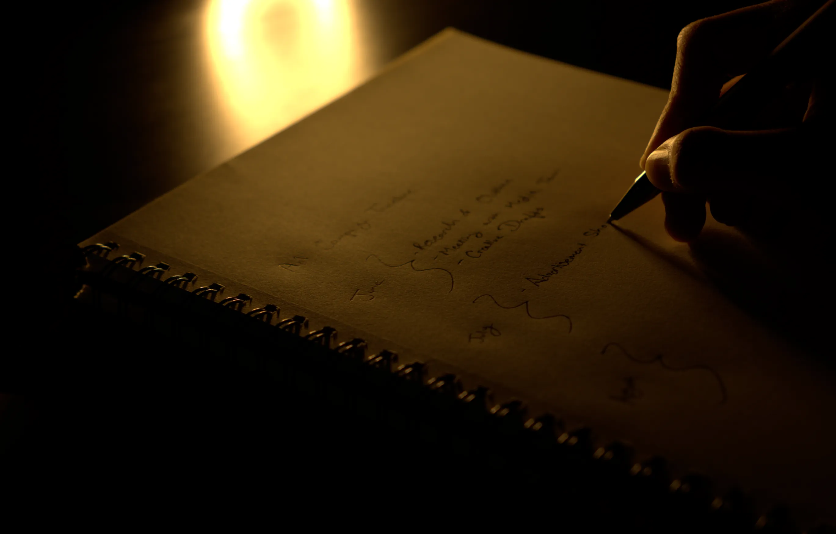 Man strategizing in his notebook, planning an advertising campaign.